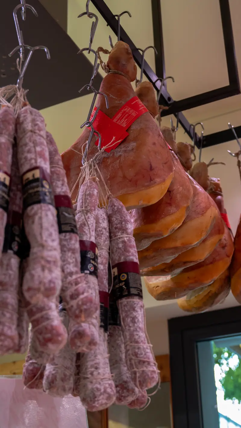 Salumi e prosciutti appesi in negozio